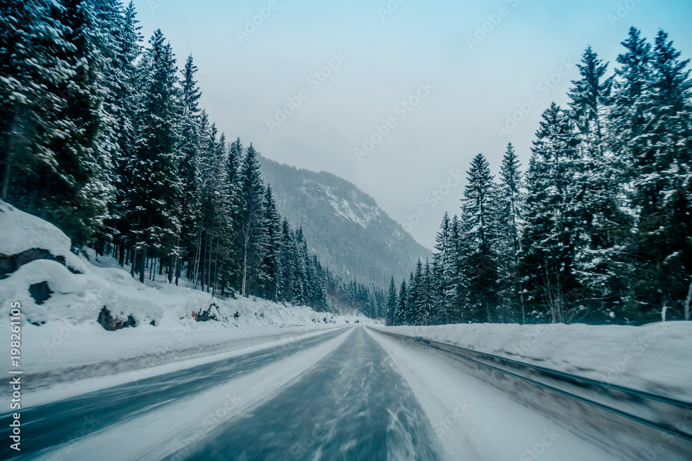 Outdoor view of winter road covered with heavy snow and ice in the forest of Norway Outdoor view of winter road covered with heavy snow and ice in the forest of Norway