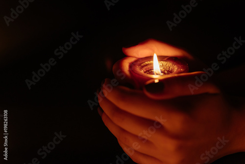 Kemerovo, Russia, fire in the mall, burning candles. Candle in female hands on black background. Many candles burning at night. Many candle flames glowing on dark background. Close-up. Free space.