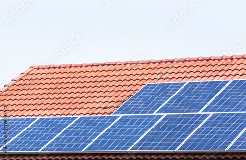rows array of polycrystalline silicon solar cells or photovoltaics installing on red concrete tiles roof house turn up skyward absorb the sunlight from the sun 