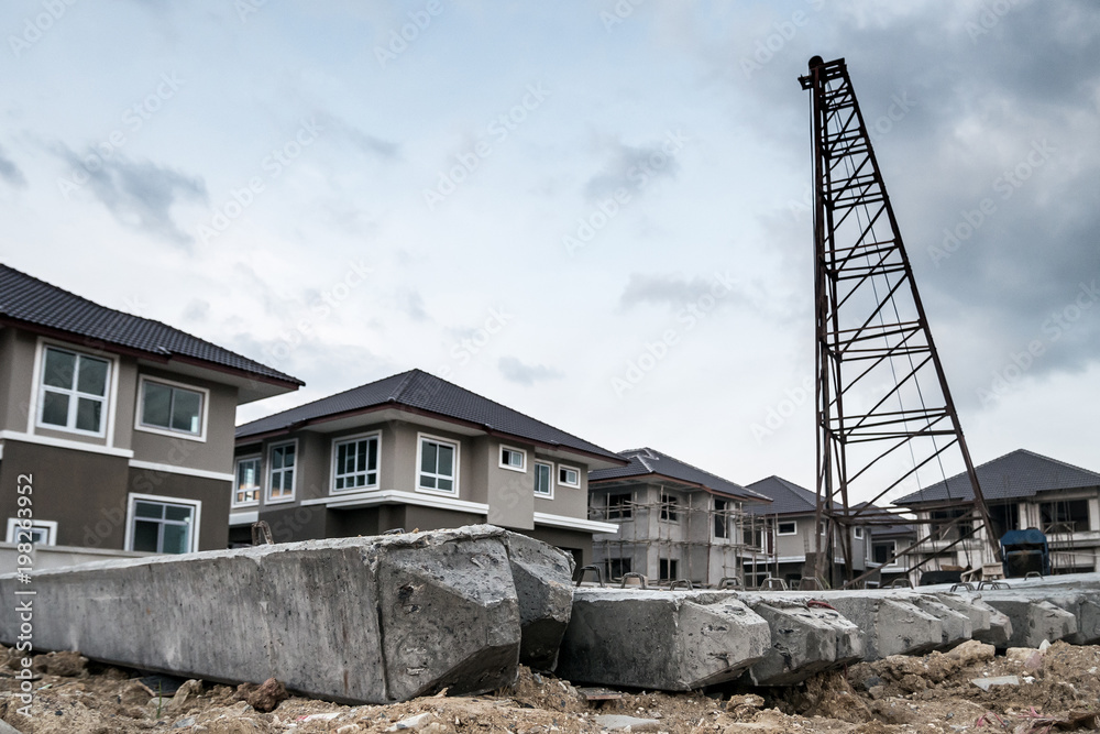 house building at construction site with pile driver and concrete piles house building at construction site with pile driver and concrete piles