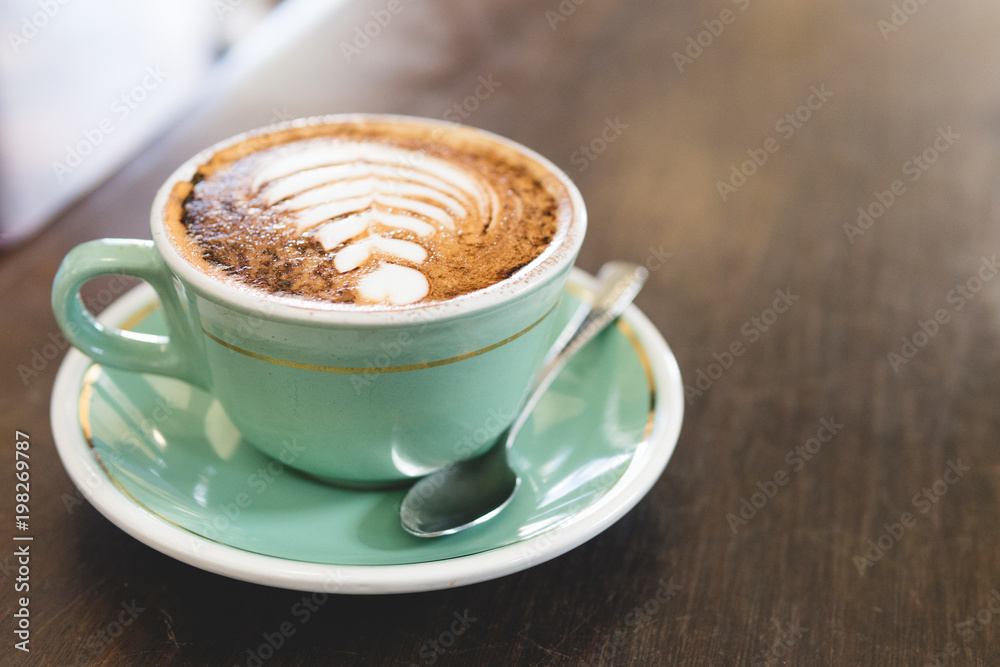Caffe Latte with latte art in green coffee cup Caffe Latte with latte art in green coffee cup