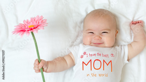 Mother's Day message with baby girl holding a flower