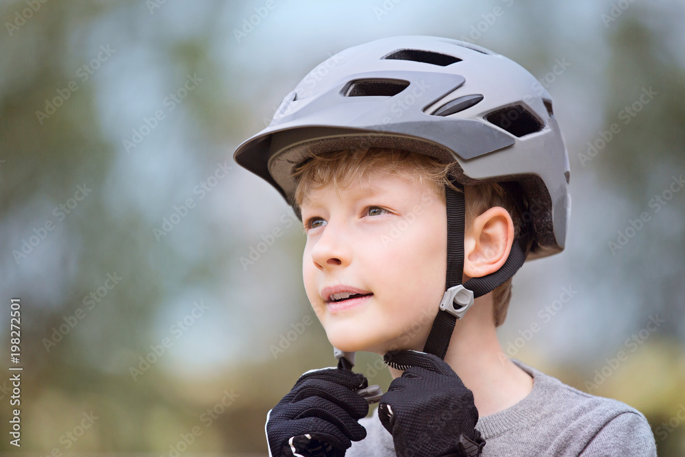 Fototapeta premium kid putting bike helmet on