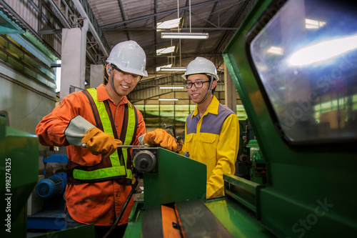 Fotografie Asian engineer and worker setting machine for process metal job