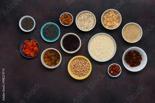 Set vegetarian healthy food - different superfood, seeds and cereal on dark background, top view. Flat lay. Clean eating concept