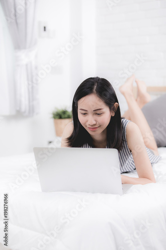 Cute Asian woman using laptop at home,