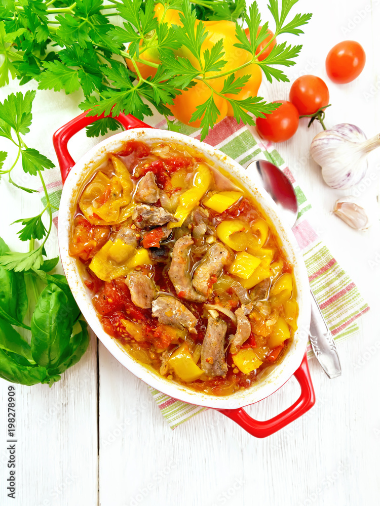 Ragout of meat and vegetables in red brazier on board top Ragout of meat and vegetables in red brazier on board top