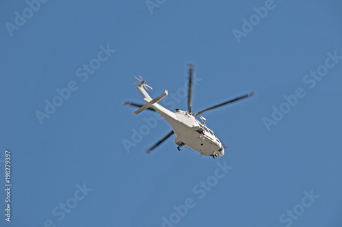 Helicopter flying overhead in a blue sky.