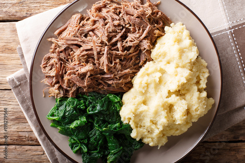 South African food: - Seswaa shredded beef with sadza porridge and spinach close-up on a plate. horizontal top view