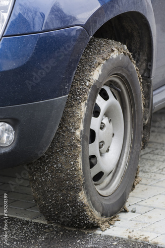 Putting mud and stones on car tires.