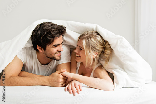 Young loving couple lying on the bed, enjoying