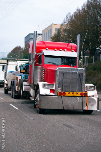 Towing semi truck tow broken big rig semi truck on the city street traffic