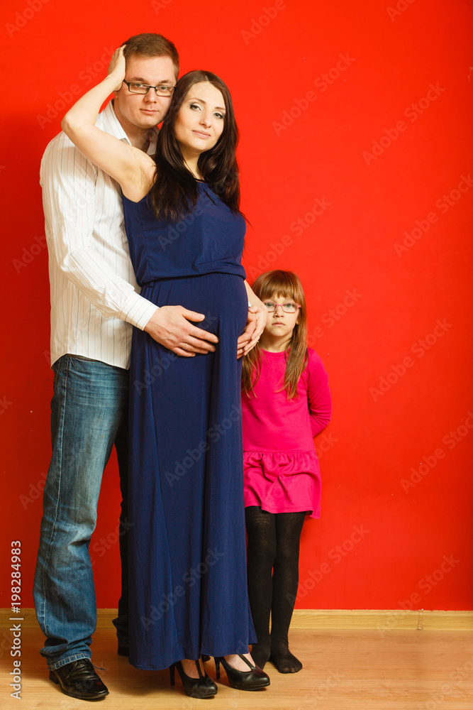 Fototapeta premium Pregnant woman, man and daughter posing.