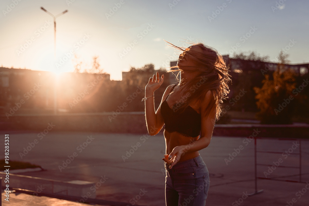emotional young girl in bra and jeans dancing in summer evening city Stock  Photo | Adobe Stock