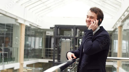 Wallpaper Mural Happy attractive young businessman using mobile phone indoors. Torontodigital.ca