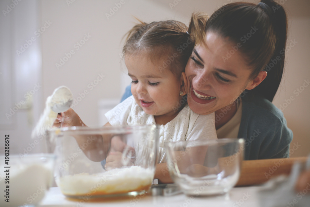 Happy mother and smiling girl baking cookies together. Happy mother and smiling girl baking cookies together.