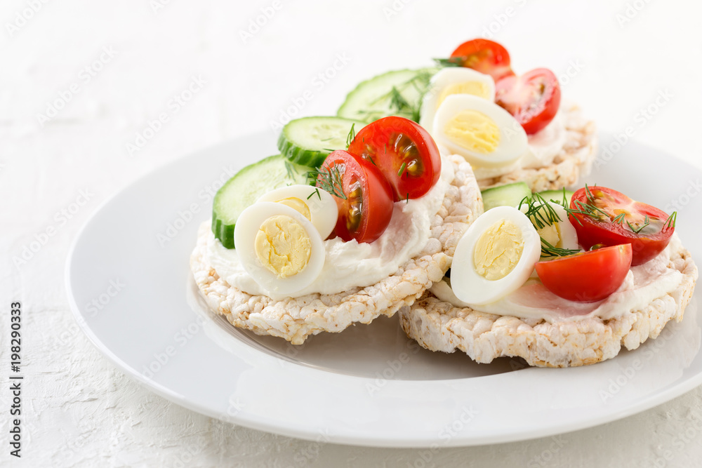 Open sandwiches of rice cakes with cream cheese , vegetables and quail egg Open sandwiches of rice cakes with cream cheese , vegetables and quail egg