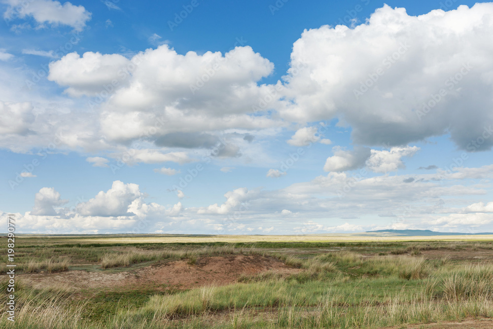 Clouds float across the sky over meadows. Tyva. Steppe. Sunny summer day. Outdoors