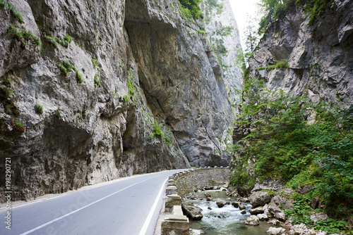 Mountain road in Bicaz Canyon  Romania between high vertical rocky cliffs. One of the most spectacular roads in Romania. Potentially dangerous hairpin curve on a mountain road.