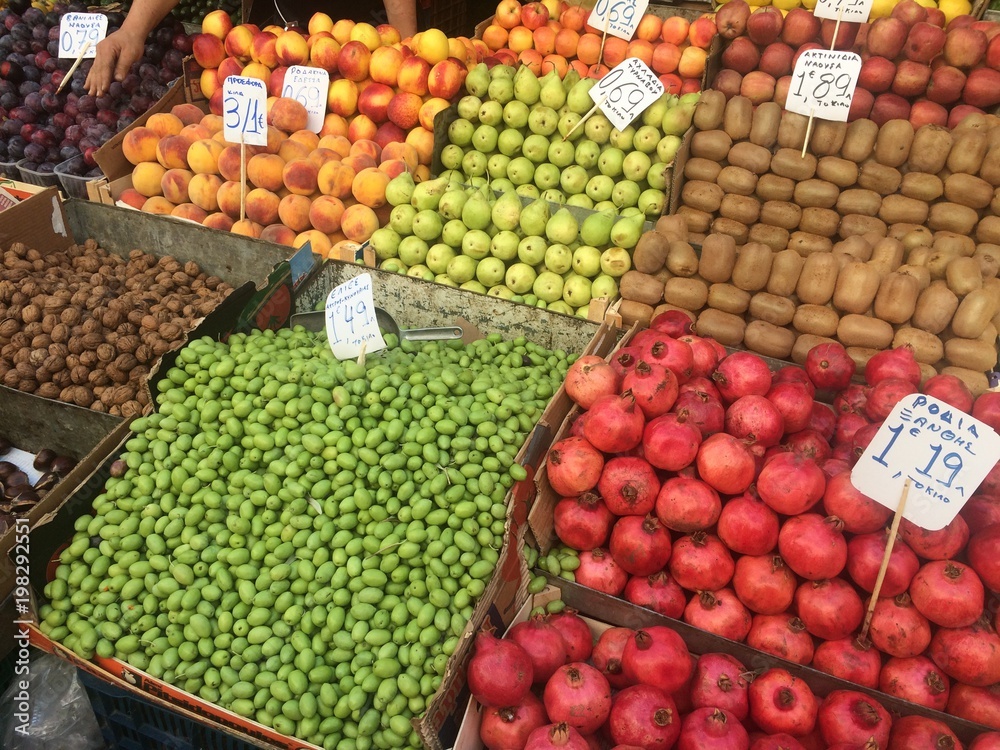 A lot of fruits in boxes in the market with price tags.