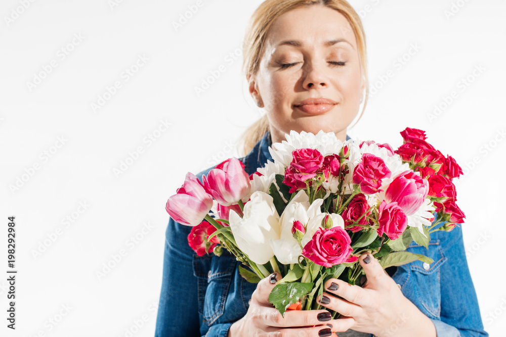 Attractive woman smelling spring flowers isolated on white Attractive woman smelling spring flowers isolated on white