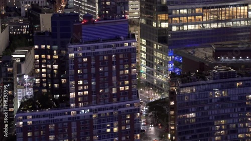 New York City low flying telephoto aerial view of Lower Manhattan Financial District buildings at night, including Goldman Sachs, Brookfield Place and World Trade Center Transportation Hub