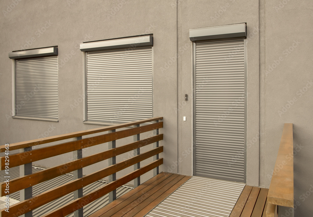Obraz premium Metal blinds on the doors and windows of the facade of the house