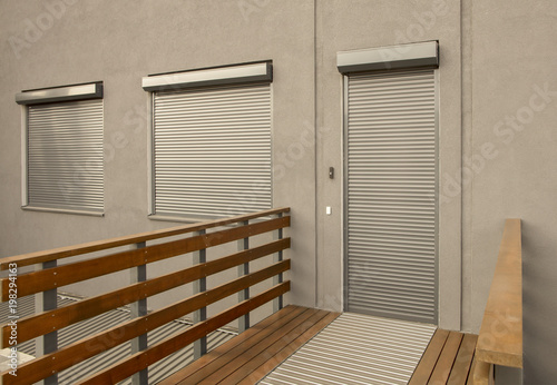 Metal blinds on the doors and windows of the facade of the house