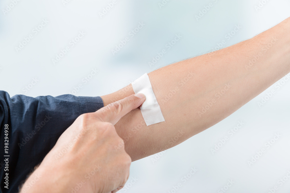 Pflaster am Arm eines Mannes nach der Blutentnahme Stock Photo | Adobe Stock