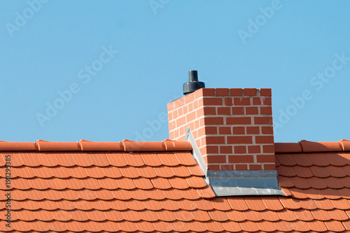 Dach mit roten Dachziegeln und Schornstein
