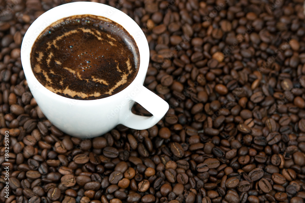 Cup of coffee on the coffee beans background. Cup of coffee on the coffee beans background.