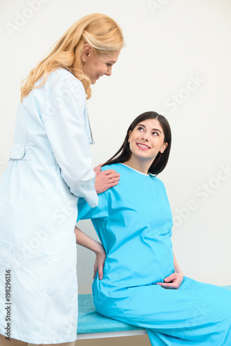 obstetrician gynecologist supporting pregnant woman before parturition