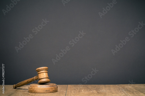 Retro auction or judge wooden gavel in front black wall background. Symbol of justice. Vintage old style filtered photo photo