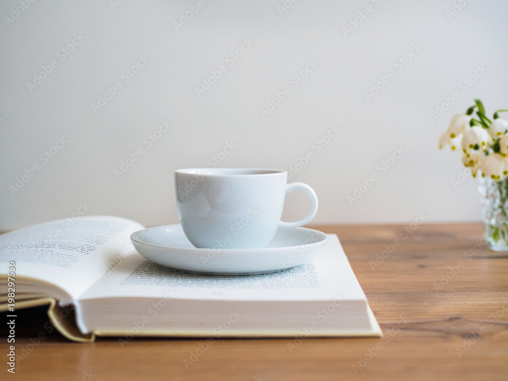 Weise Tasse auf einem offenen Buch Weise Tasse auf einem offenen Buch