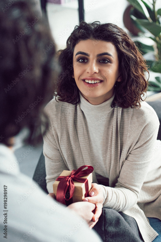cropped image of boyfriend presenting gift to girlfriend at home cropped image of boyfriend presenting gift to girlfriend at home