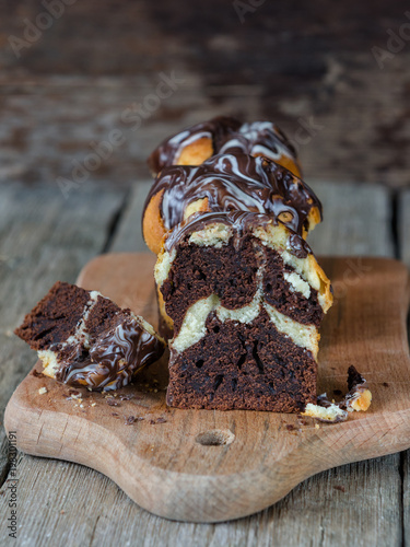 Tasty muffins on a wooden cutting board on a cake background, close-up, cupcakes black and white, chocolate and vanilla, zebra cake for breakfast or a family picnic.