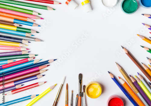 Top view of paint brushes, color pencils and watercolors