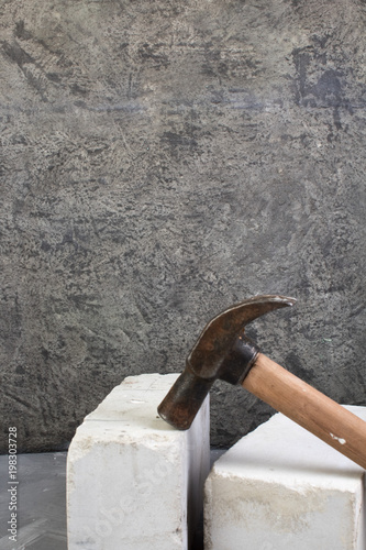 bricks, hammer on the gray concrete background. Copy space. Top view. photo