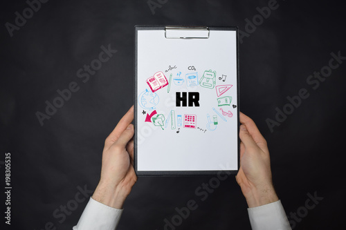 In the hands of a businessman a notebook with the inscription:HR