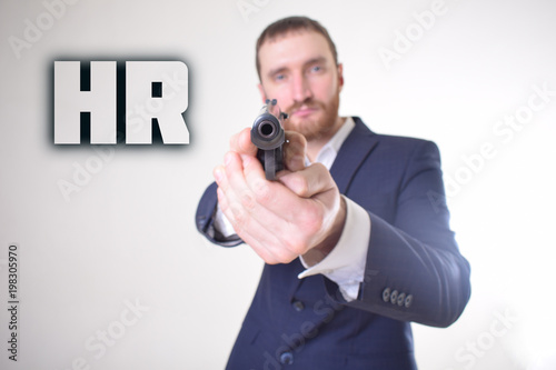 The businessman holds a gun in his hand and shows the inscription:HR