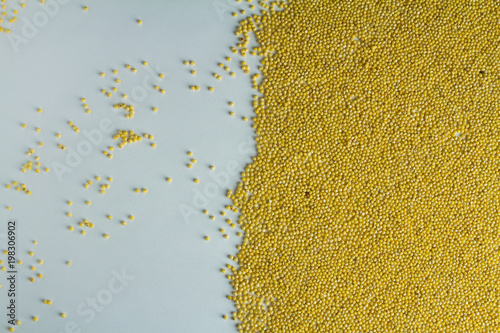 Millet is evenly scattered on a white table.