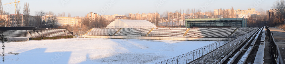Fototapeta premium Bucharest, Sportul Studentesc stadium in the winter. Panorama of empty stadium covered in snow.