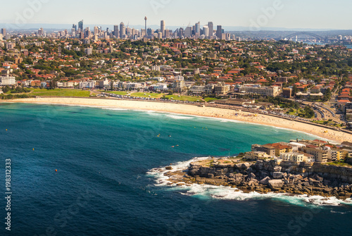 Aerial view from a small plane of Bondi beach, Sydney, Australia. A group of people can be seen gathered on the golden sand.