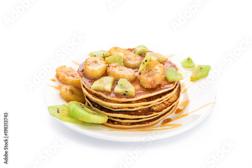 Stack of pancakes isolated on white background. Delicious breakfast with a grilled bananas and a caramel  kiwi slices. Top view  flat lay