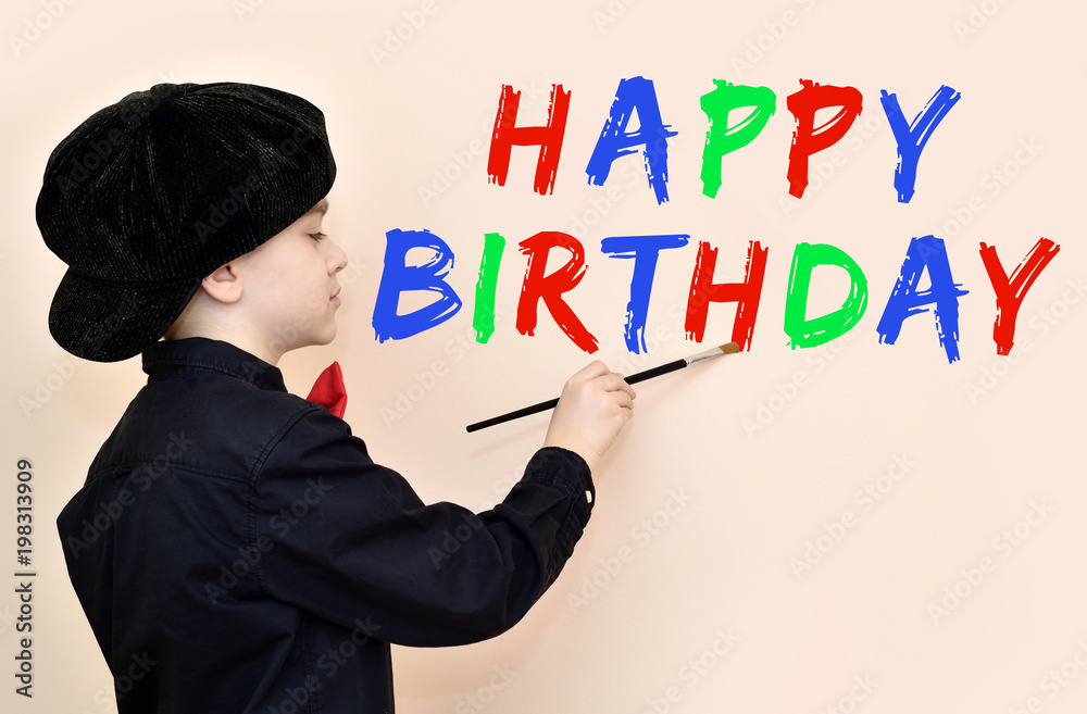 Young painter with black shirt and cap writing with the paint brush HAPPY BIRTHDAY on the wall Young painter with black shirt and cap writing with the paint brush HAPPY BIRTHDAY on the wall