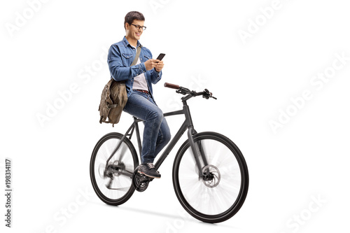 Young man riding a bicycle and using a phone