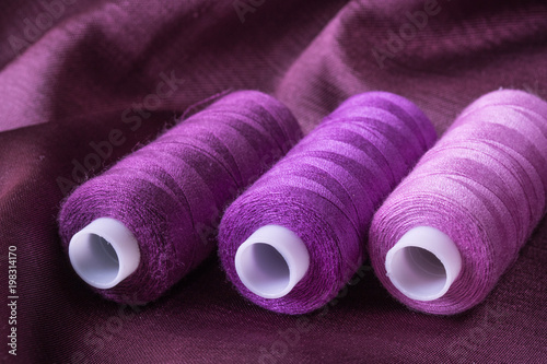 Purple fabric background and texture, Crumpled of violet satin with sewing thread coils