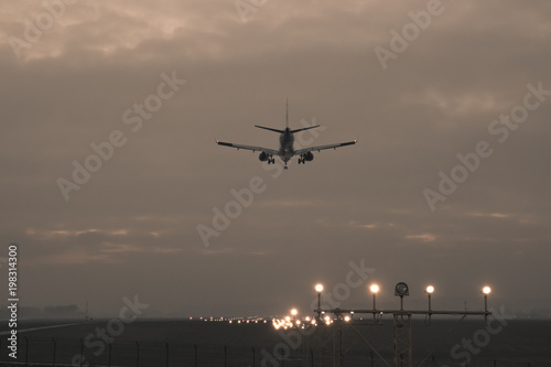 A passenger plane is landing on the background of the twilight, photo in retro style © Bogdan