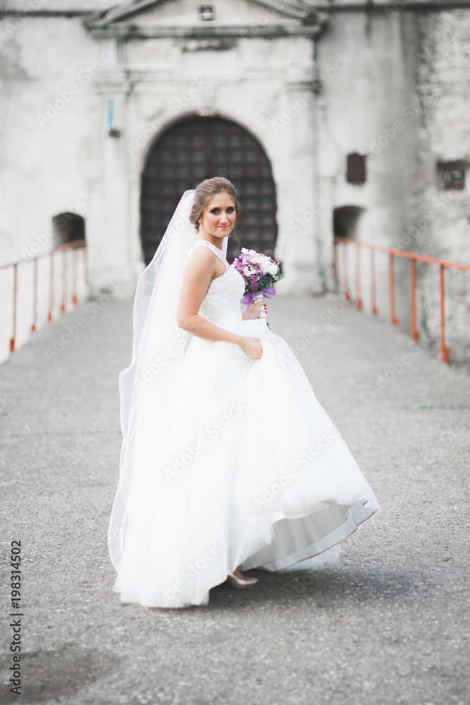 Portrait of stunning bride with long hair posing with great bouquet Portrait of stunning bride with long hair posing with great bouquet