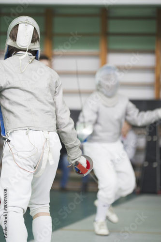 Two young fencers fighting on the fencing competition